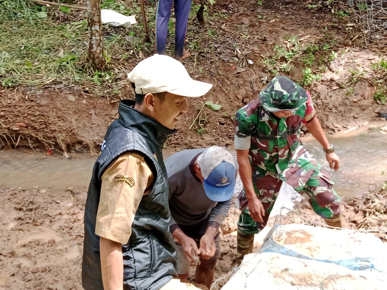 Babinsa Koramil 1002/Cimalaka Kodim 0610/Sumedang Serda Selamet N melaksanakan kegiatan Kerja Bakti pemasangan bronjong